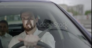 Young taxi driver with a beard is driving on the green light