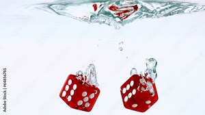 Two red dice falling in water