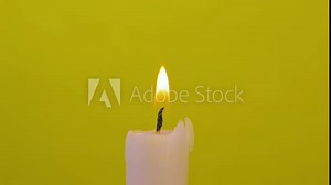 Close-up of candle wick lit with splinter on yellow background and then it is blown out