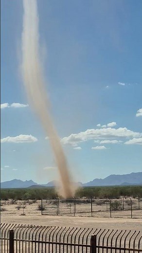Dust devil forms near water tower in San Simon, Arizona, USA