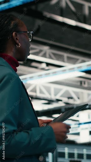 Vertical video Writing code, tablet and female programmer walking in data center, compiling software patches. Running programming script, device application and African american woman in server hub