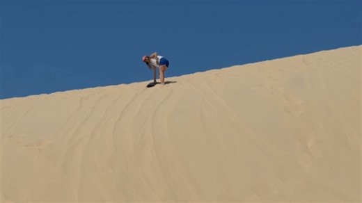 Girl Loses Balance and Falls While Riding Down a Sand Dune