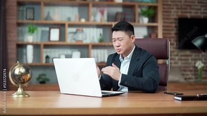 Dissatisfied with the results businessman looking at laptop computer screen in the office. Angry middle aged asian business man lawyer attorney analyst manager banker boss bad work fail and failure
