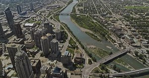 Calgary AB Canada Aerial v10 birds eye view flyover riverside Downtown West End capturing Bow river, bridges and cityscape of Beltline and Commercial districts - Shot with Mavic 3 Pro Cine - July 2023
