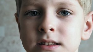 The boy opens his mouth and shows the lost tooth