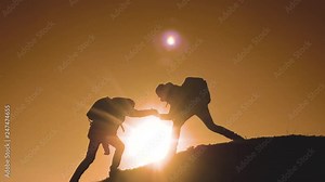 teamwork people tourists business travel trip lends a helping hand. two men with backpacks hiking lifestyle help each other silhouette in mountains with sunlight. slow motion video. teamwork