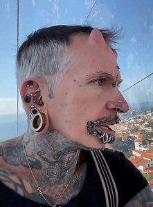 Cet homme a plus de 560 piercings sur le corps, ce qui lui a valu un record mondial 😱 En plus des piercings, il possède des implants en forme de cornes sur le front, et son corps est presque entièrement couvert de tatouages 😨 Mais le plus étonnant, c’est qu’autrefois, il était un simple employé de bureau, et qu’il a fait son premier piercing à 40 ans 😱😱 Son apparence avant toutes ces transformations a été montrée dans le premier commentaire 👇👇 | Amour sans limites