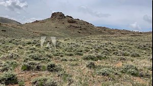 Wyoming landscape with sage brush and rocky buttes. Time Lapse shows rolling clouds and shadows.