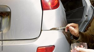 paint rust and corrosion on the car with a brush with a rust converter, restoration work of the car body