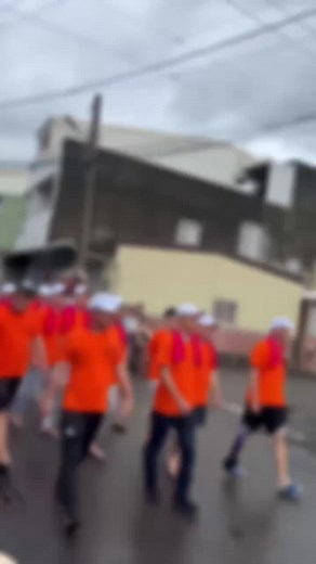Urban Procession in Bright Orange Shirts and Caps
