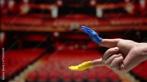 Tiny hand puppet clapping in an empty theater