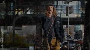 Man before glass facade raising device to mouth, speaking, giving tech input, HUD overlaying facade