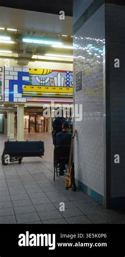 New York, USA, 2 March 2026: Police officer talking to street musician in New York subway. Law enforcement officer interacting with a bass guitar player in a tiled underground station Stock Video Footage - Alamy