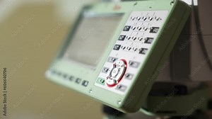 A man's hand presses buttons with a stylus on the control panel. Geodetic Tool Control Panel.