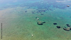 Beautiful aerial footage of the clear ocean sea off the Greek coast of Greece in Corfu showing a boat traveling in the ocean