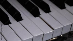 Piano or Grand Piano Playing Itself. Performing a musical composition on a piano that plays by itself. Self-Playing. White, black piano keys press independently without human intervention. Close up.