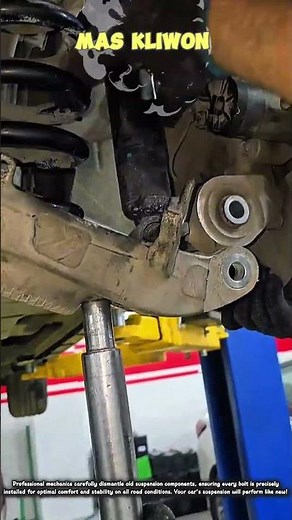mechanic performing repairs on the car's rear suspension system