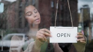 cafe or restaurants and business reopen after coronavirus quarantine is over. woman with face mask turning a sign on a door shop. small business after covid lockdown. small business open sign. Stock Video