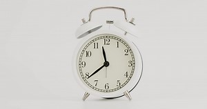 Download White alarm clock with time position on a white background. for free