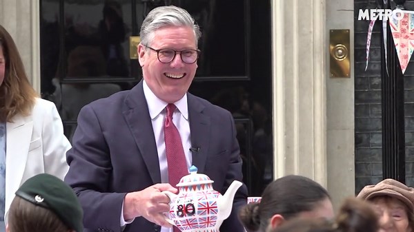 Kier Starmer pours tea for guests at VE Day street party