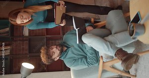 Female assistant going over details with her boss, vertical video, teal and orange, trucking movement