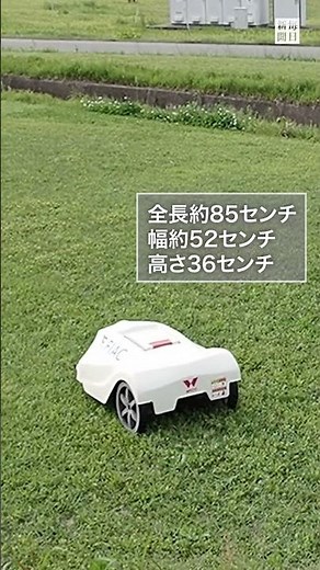 A white robotic lawnmower working diligently at Fukuoka Airport.