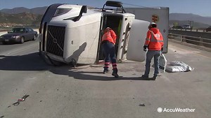 Tractor trailers pushed over by powerful winds