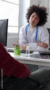 Female doctor and male patient talking in a medical consultation in a clinic. Vertical screen video footage