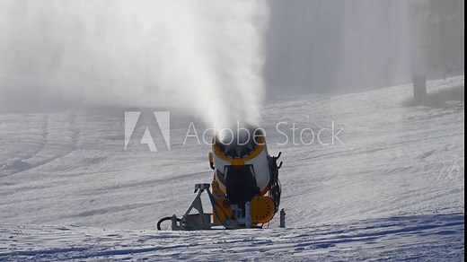 4K video of a snow gun or snow cannon producing snow through the snowmaking process. Filmed in winter at the outdoor ski resort slopes.