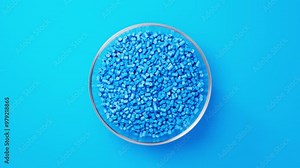 Rotating glass bowl with blue plastic polypropylene granules, masterbatch polymer grain on blue backdrop. HDPE or PVC resin pellets. 3d render animation