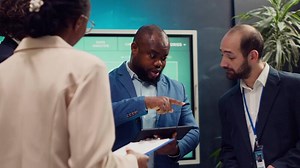 Supervisor and employees attend a status update meeting with their progress portfolios on the current business project. Team leader reviewing marketing strategies and budget planning. Camera A.