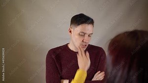Crop person slapping scared man in face. Emotional male getting slapped in face while shouting with closed eyes in fear on white background