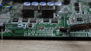 soldering a computer board, changing components with a metal hot soldering iron. soldering iron and electronics repair concept