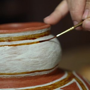 Painting organic paint on my Tonto Polychrome replica pot. The paint is made from mesquite beans. This will carbonize to create black designs in the firing. | Andy Ward's Ancient Pottery