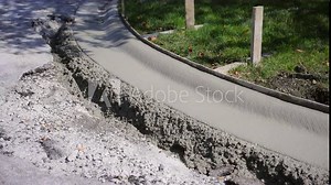 Concrete curb at road construction site. The road is Installation of concrete curbs during road construction. Laying Sidewalk Curbs