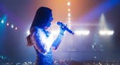 Female Pop Artist Performing Live Concert on Stage, Illuminated by...