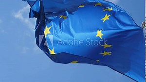 The EU banner flying high in windy weather in a light blue sky in slo-mo