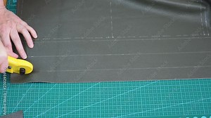 craftsman cuts green leather using rotary cutter knife Stock Video