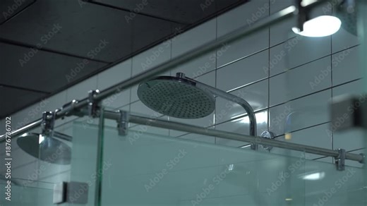 Glass Shower Cabin with Rainfall Shower Head in Modern Sports Club Locker Room, Premium Wellness and Fitness Center Interior, Clean Minimal Bathroom Design, Stainless Steel Fixture