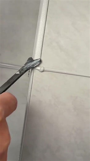 applying white cement on wall tile gaps using tools to achieve very neat and also very smooth