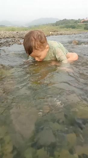 Toddler Enjoys Playtime in a Serene Stream Setting