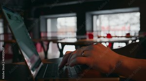 Close-up, a hacker or Internet fraudster opens a laptop and starts working, typing text on the keyboard. There is only a laptop and hands in the frame. An unrecognizable face. High quality 4k footage