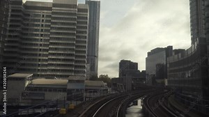London Docklands next to underground and docklands light railway DLR station. View from the DLR railway train approaching the station at Canary Wharf, London. Action. Overground railway