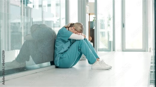 Healthcare, stress and sad nurse on floor by anxiety, burnout and headache while in emergency services. Medical care, mental health and professional worker with depression in hospital or clinic