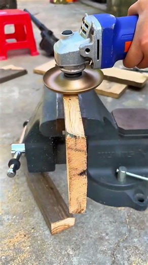 using an angle grinder to remove old layers of paint and smooth out the rough wooden surface