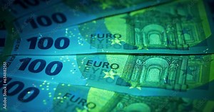 Euro banknotes under ultraviolet light. Security signs and elements on real 100 euro banknotes glow under UV light. Checking banknotes for authenticity. Protection against counterfeiters