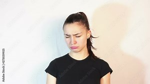 Young beautiful girl is very upset. Face expresses annoyance and sadness. Portrait on white background