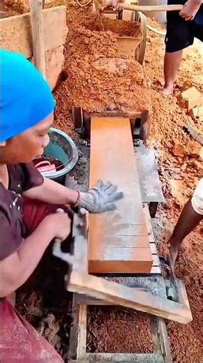 Brick making worker cutting a newly extruded clay block into uniform pieces on a production line