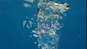 apture motion descent of plastic and metal debris underwater, emitting air bubbles. Unfiltered waste sinks, exacerbates global oceanic pollution