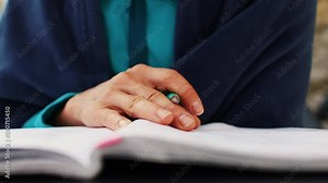 Woman works remotely, higher education for adults, woman writes in a notebook, female hands and a pen close-up, freelancer does work in nature